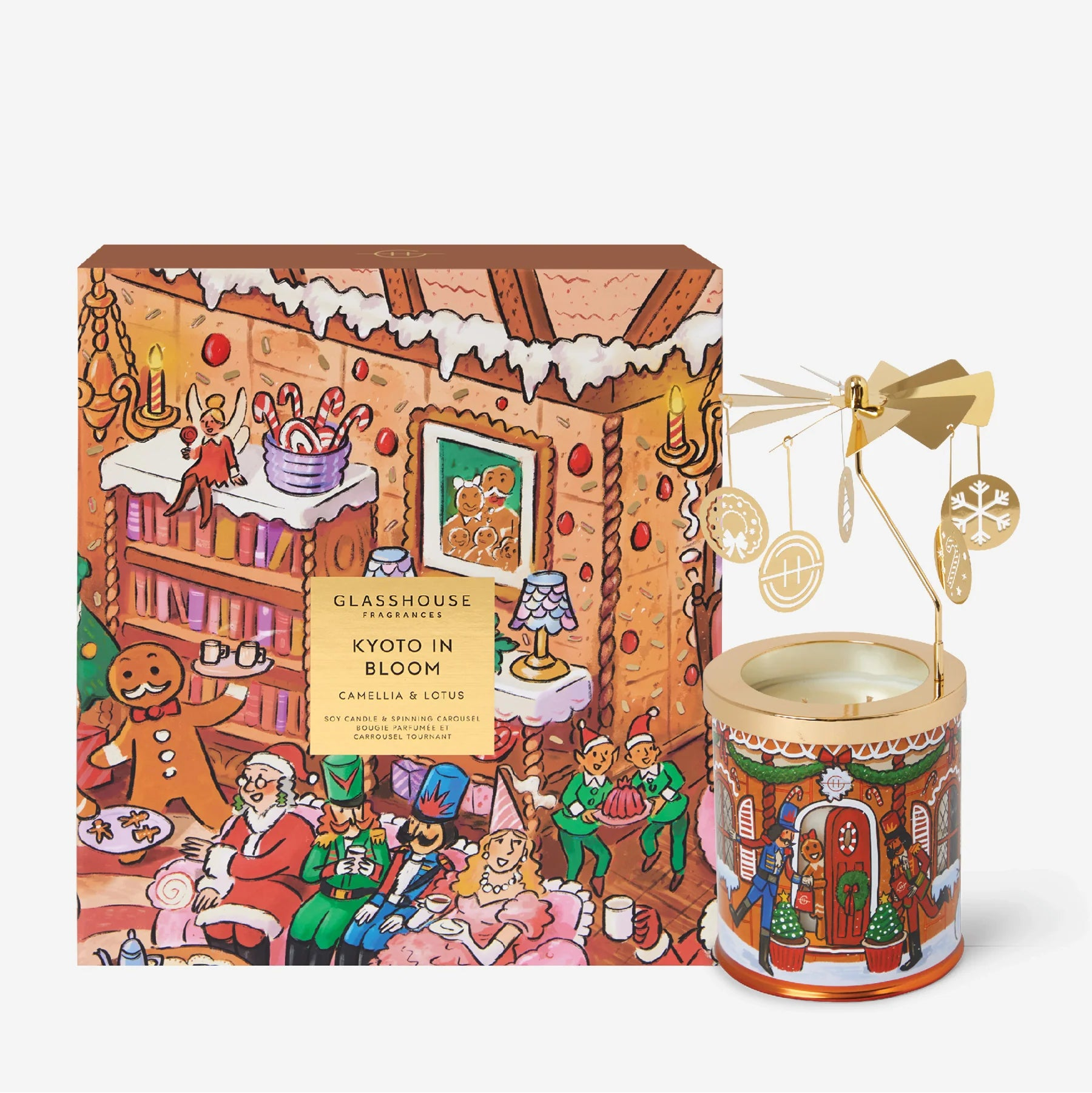 A Christmas-themed scented candle set by Glasshouse, featuring a colorful illustrated box labeled 'Kyoto in Bloom' and a matching candle tin with a gold wind spinner on a light gray background.