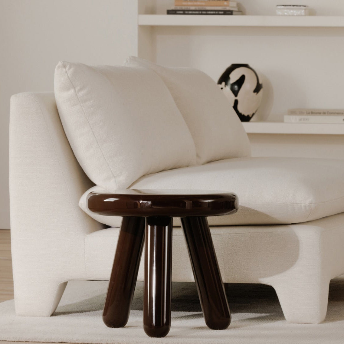 Modern white sofa with a wooden side table in a minimalistic living room.