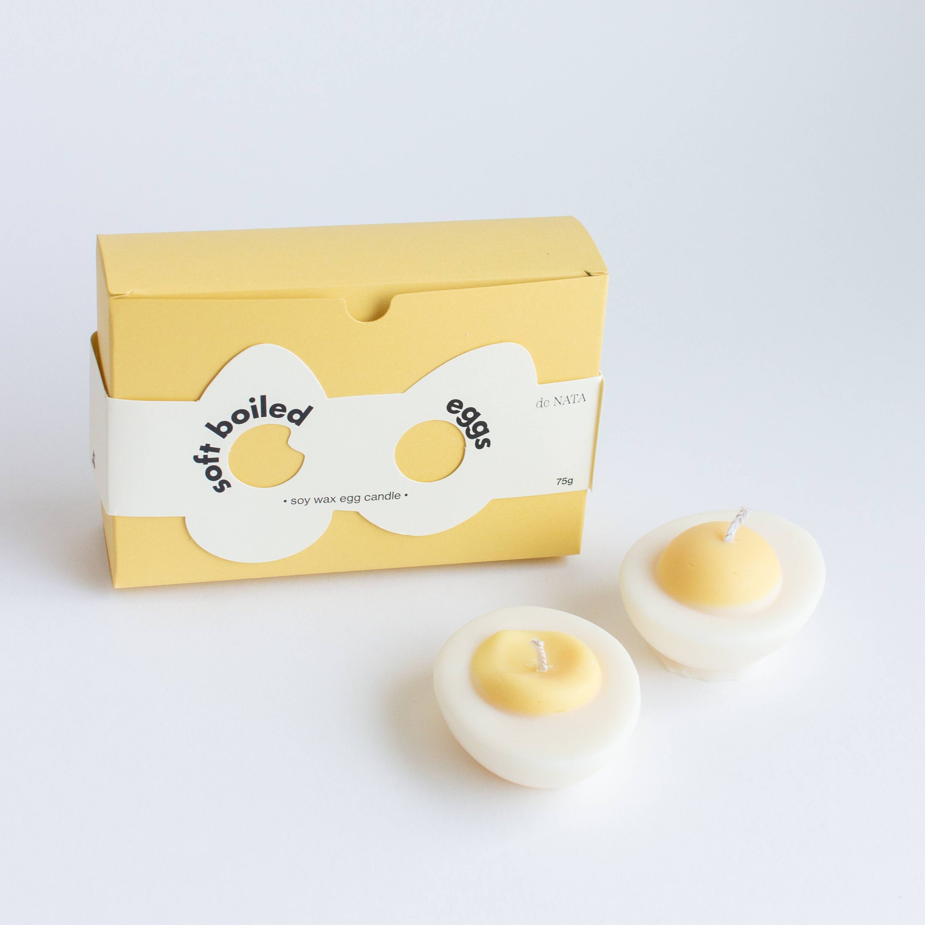 Candle shaped like a boiled egg with a matching box on a white background