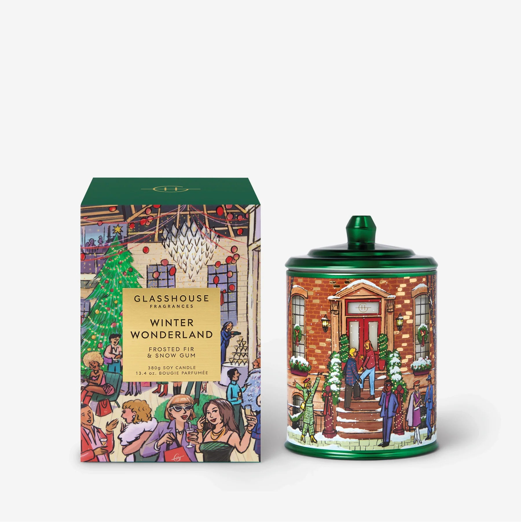 A Christmas-themed scented candle and its matching box from the brand GLASSHOUSE, featuring a colorful winter village illustration on both the candle container and the packaging.
