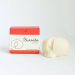 Burrata cheese-shaped candle with packaging on a white background