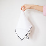 white linen napkin with black edge