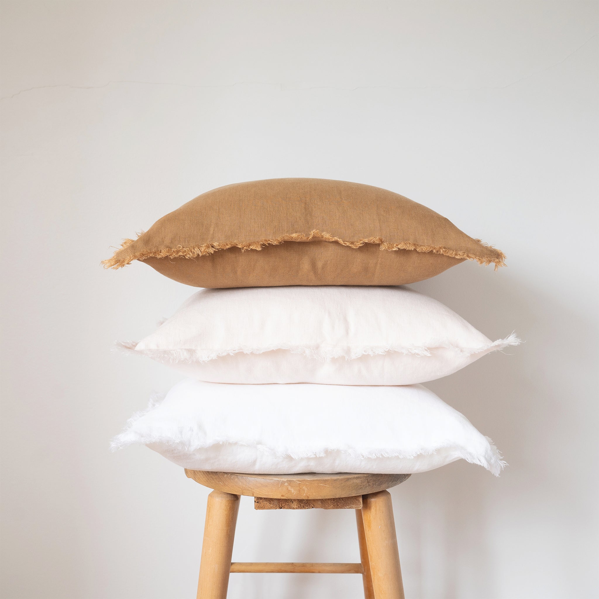 camel, blush, and white square fringed linen pillow